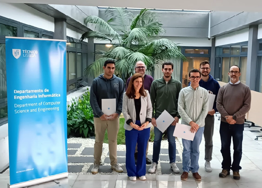 Grupo de estudantes e professores do Departamento de Engenharia Informática do Técnico Lisboa posa para uma foto a segurar os certificados. A imagem representa reconhecimento académico, excelência educacional e progresso tecnológico.