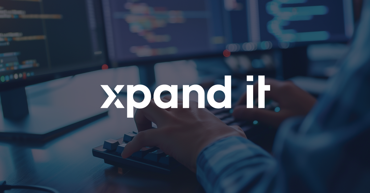 Man coding at a workstation with multiple monitors displaying code, with the "Xpand IT" branding overlaid at the center of the image.