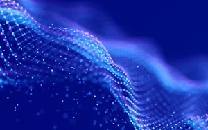 Malha de pontos digitais em tons azulados a formar uma onda abstrata sobre fundo escuro, representando conectividade e dados.