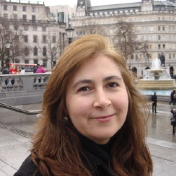 Portrait of a smiling woman in an urban setting.