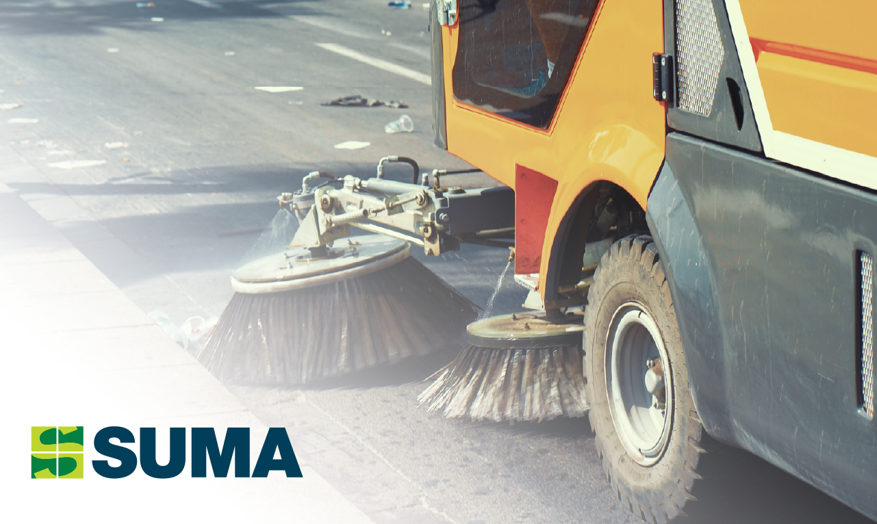 Detalhe de veículo de limpeza urbana em contexto de rua com marca SUMA visível.