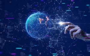 Mão humana a interagir com uma representação digital do globo terrestre, conectada a redes de dados e elementos de código num fundo escuro.