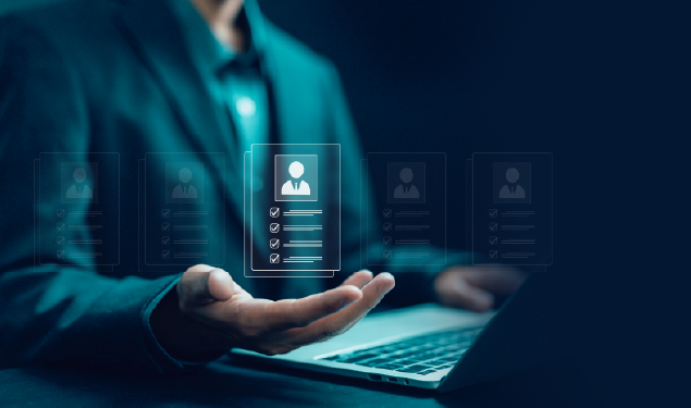 Homem de fato a utilizar um computador portátil com ícones digitais de perfis de utilizador e listas de verificação a flutuar sobre a sua mão. A imagem representa gestão digital de informação pessoal, recrutamento ou automação de processos de recursos humanos.