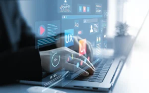 Close-up of hands using a laptop with UI and UX visual elements, illustrating interface design, user experience analysis, and digital product development.