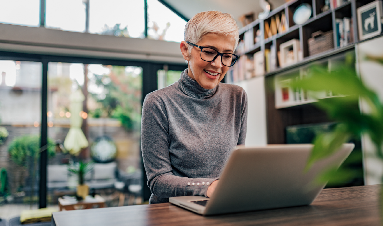 Mulher a trabalhar num computador portátil num ambiente profissional, representando a adoção de novas formas de trabalho com tecnologia e IA.