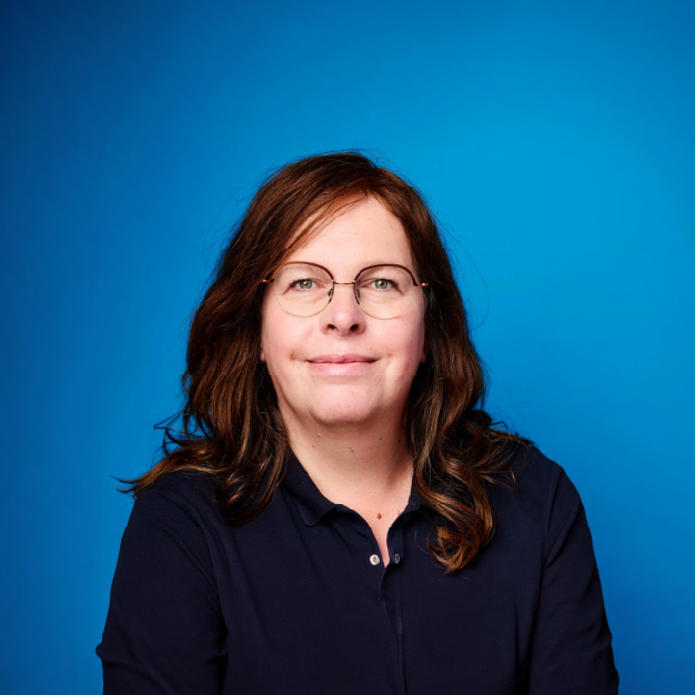 Retrato da oradora Suzanne Daniels sobre fundo azul.