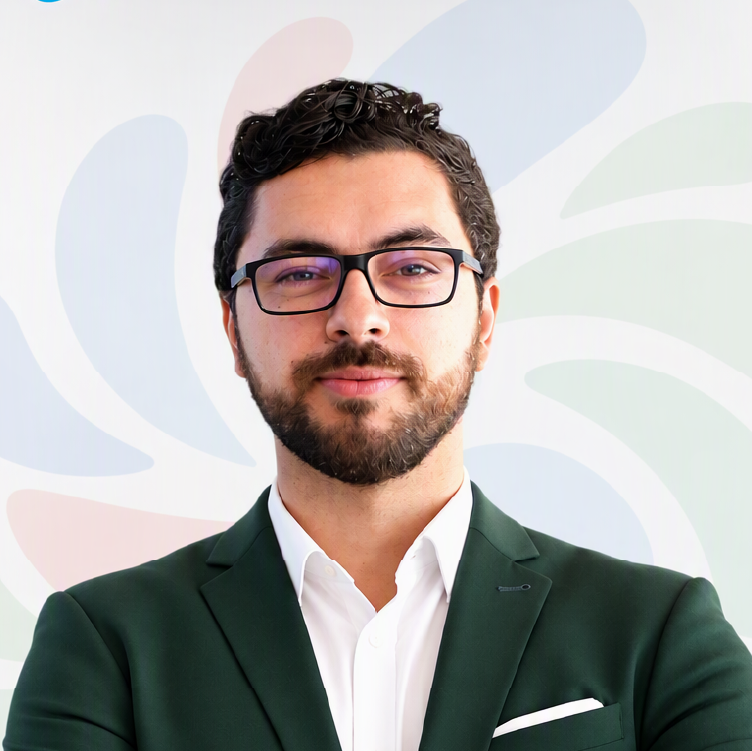 Retrato de César Augusto, da Sumol Compal, com blazer verde-escuro, camisa branca, barba e óculos, sobre um fundo claro com elementos gráficos.